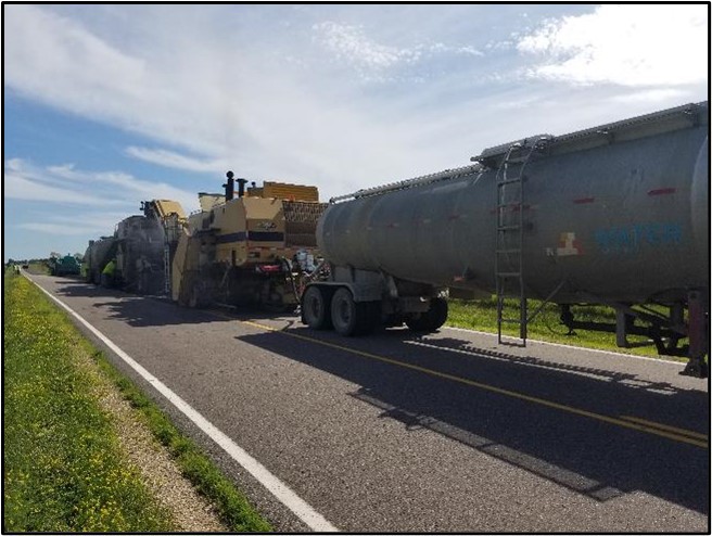 A convoy of equipment finishes road surface. 