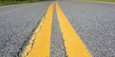 Double solid yellow line markers on the center of a road.