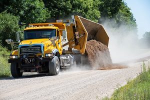 Side dumping plow truck on a gravel road